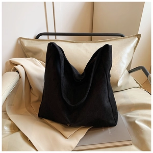 Minimalist black matte large capacity hobo tote bag placed on a cozy beige sofa