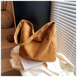 Detail of vintage ginger frosted suede tote bag with wide shoulder strap on white blazer