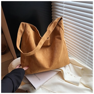 Macro shot of large tan suede tote bag with wide shoulder strap and matte velvet texture