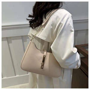 Detail of minimalist cream leather underarm bag with gold hardware on trench coat