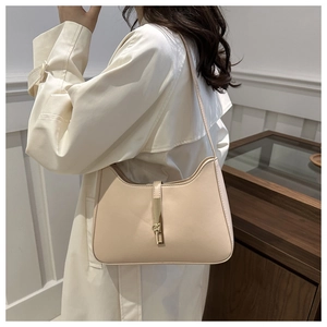 Detail of elegant beige hobo bag showing gold piston lock and premium leather texture