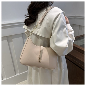 Detail of beige leather crescent shoulder bag with gold chain and metal clasps