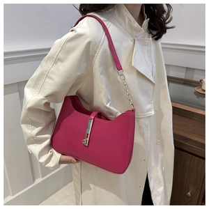 Detailed close-up of rose pink crescent bag with golden chain and piston closure