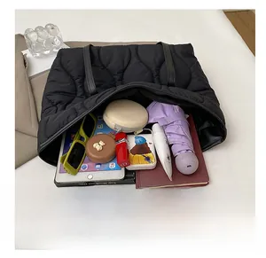 Détail montrant le grand intérieur du sac fourre-tout matelassé noir pour les objets