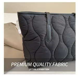 Détail du tissu du sac cabas noir matelassé avec coutures ondulées élégantes
