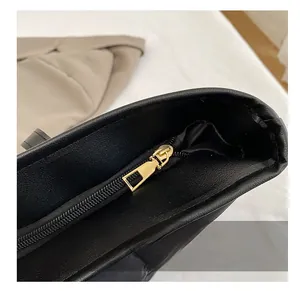 Gros plan sur la fermeture éclair en métal doré lisse d'un sac cabas en cuir noir