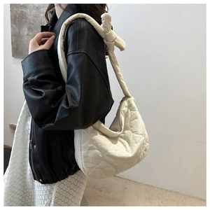 Detail of heart quilted nylon shoulder bag with knotted strap and zipper closure