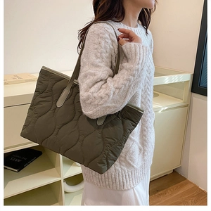 Detail of the wave-quilted dark olive green nylon tote bag with long shoulder strap