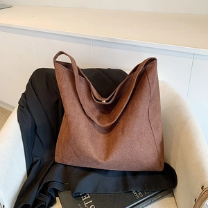 Retro large brown suede tote bag with matte texture on white chair in modern setting