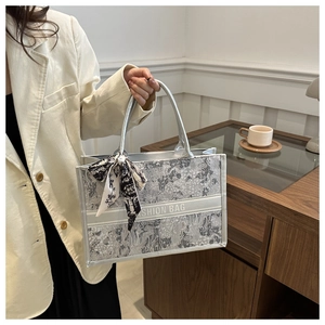 Detail der silbernen Blütentasche mit Seidenschal-Griff und 'Fashion Bag' Aufdruck