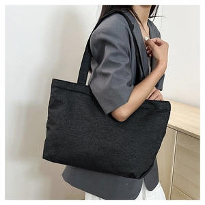 Minimalist black canvas tote bag shown on a model for a stylish casual daily commute