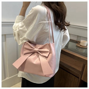 Detail of pink bow tote bag showing large decorative knot and slim shoulder strap style