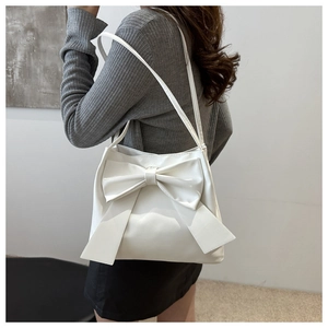 Detailed back view of a white PU tote bag with a large bow worn by a model