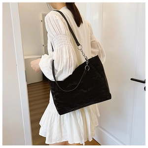 Détail du sac cabas plissé noir montrant la texture du tissu et la bandoulière chaîne
