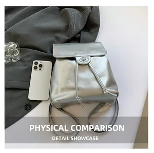 Detail of silver metallic backpack featuring a drawstring closure and a fashion logo flap