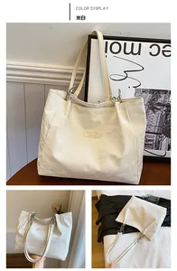 Détail du sac cabas blanc cassé avec texture plissée et anneaux en métal argenté