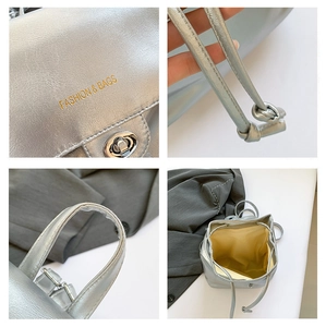 Detailed close-up of silver bucket bag with drawstring closure and golden logo stamp