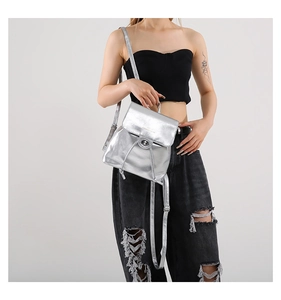 Detail of silver metallic bucket backpack with drawstring and classic twist lock buckle