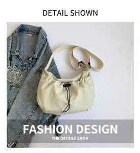 Detail view of the pleated beige crossbody bag with a drawstring closure and fabric strap
