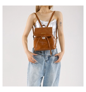 Detail of vintage brown PU leather backpack with silver rotary lock and fashion logo