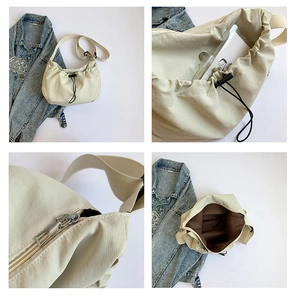 Detail view of large capacity off-white crossbody bag with drawstring and zipper closure