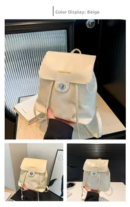 Detailed close-up of beige faux leather backpack with gold twist lock and drawstring closure