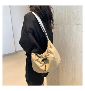 Detail view of the drawstring closure and nylon fabric texture on half moon crossbody bag