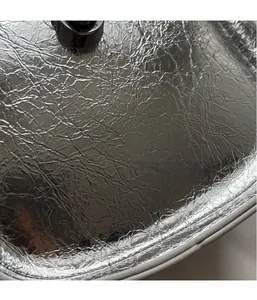 Detailed macro view of the silver metallic pleated fabric on a lightweight crossbody bag