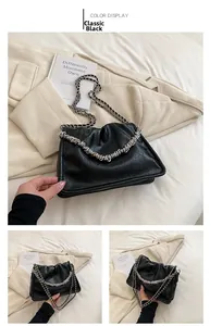 Detail of black pleated cloud bag featuring chunky silver chain and faux leather texture