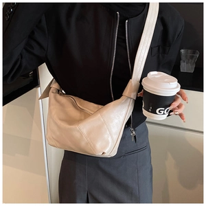 Detail of off-white faux leather dumpling bag with diagonal stitching and soft texture