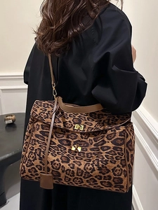 Large leopard print tote bag with brown leather trim and golden square locks shown on model