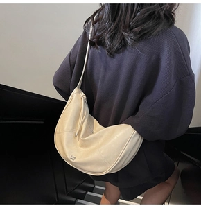Detailansicht der beigen Softleder-Umhängetasche mit Ziernähten und Logo-Applikation