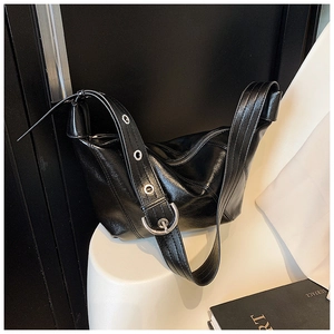 Detail of black pleated leather crescent bag with metallic silver buckle and eyelets