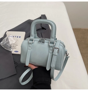 Detail of light blue Boston bag with matte PU leather, dual zippers and thin shoulder strap
