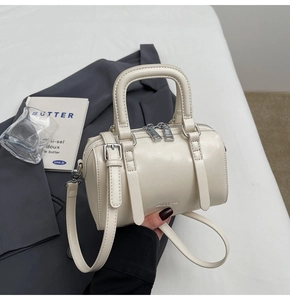 Detail of cream white Boston bag featuring smooth leather and silver hardware accents