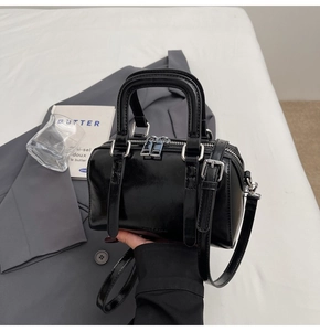 Close-up of black glazed leather Boston bag with silver hardware and chic hand-held styling
