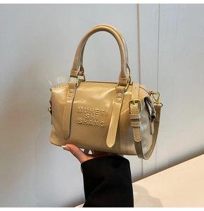 Dettaglio della borsa Boston beige con logo a rilievo e accessori in metallo dorato