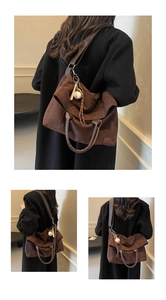 Dettaglio della grande borsa tote in pelle scamosciata marrone con ciondolo da baseball