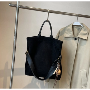 Borsa tote in camoscio nero appesa a una gruccia argentata con dettagli in stile urbano