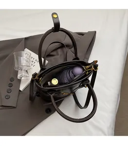Vue intérieure du sac seau en cuir marron foncé montrant l'espace pour parapluie et parfum