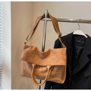 Dettaglio di una borsa tote marrone opaca con tracolla regolabile e design minimalista