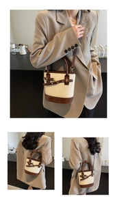 Détail du sac seau crème et marron avec bandoulière amovible et finitions dorées