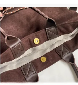 Dettaglio della borsa tote marrone scuro con chiusura magnetica e fodera a spina di pesce