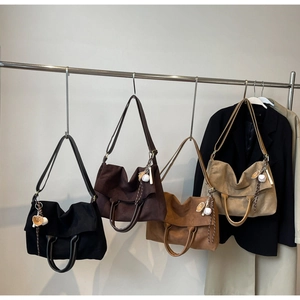 Dettaglio di borse tote minimaliste in quattro colori con ciondoli da baseball
