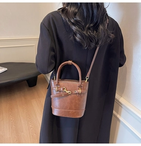Détail d'un sac seau vintage en cuir PU marron avec bandoulière réglable et fermoir