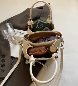 Detail of cream bucket bag with multi-compartment interior for phone and wallet