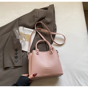 Detailed texture of pink litchi grain leather bucket bag with brand embossing