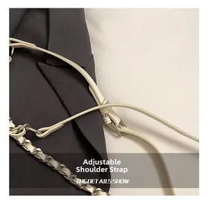 Détail de la bandoulière réglable en cuir avec chaîne en métal argenté sur un sac blanc