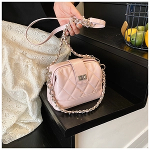 Détail du sac à main matelassé rose avec fermoir rotatif argenté et chaîne
