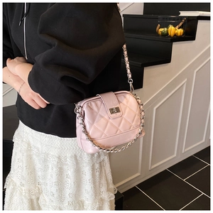 Sac bandoulière matelassé rose avec chaîne argentée porté dans un style de rue chic